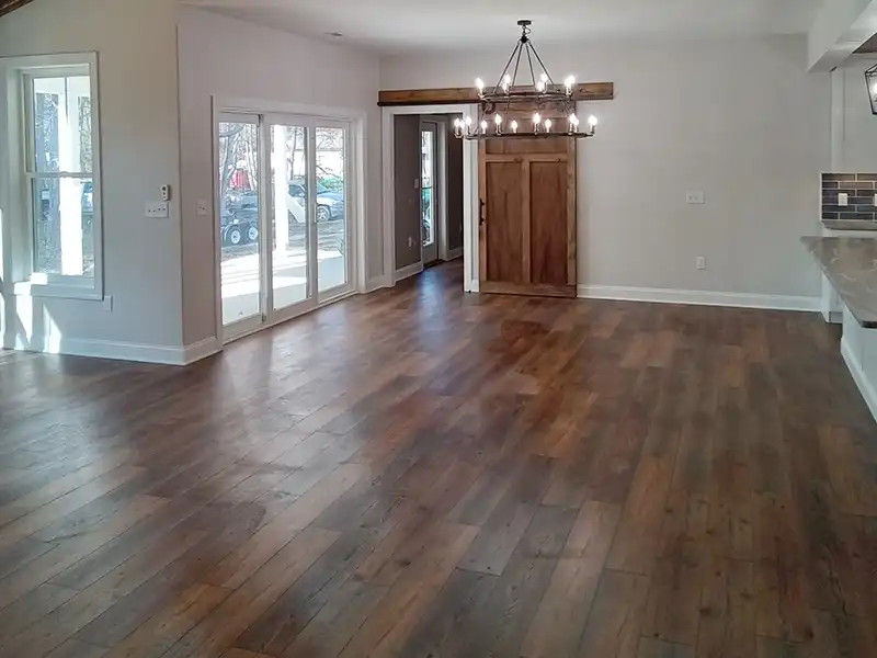 Empty living room space with new brown wood flooring